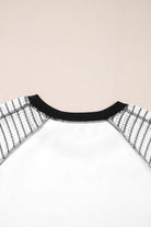 Back view of the Fine Line Top, featuring black striped raglan sleeves and a sleek patchwork design.