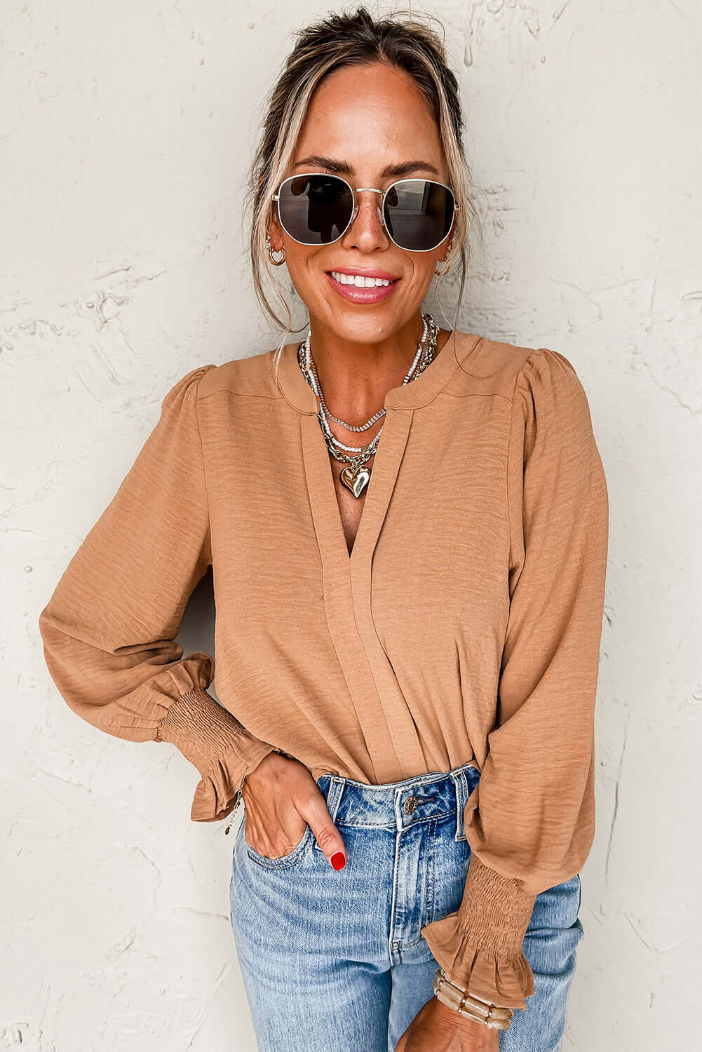 Woman wearing BEAUTIFUL YOU Top by Vivian-Lu, featuring V neck notch and shirred cuffs, styled with sunglasses and jeans.