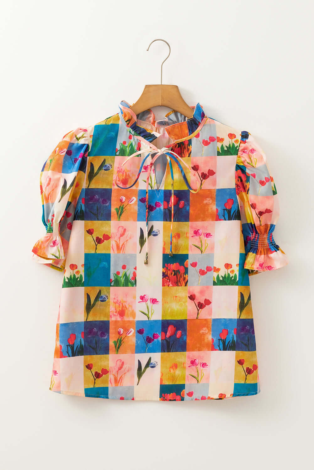 Colorful floral checker print blouse with puff sleeves and tie neckline, perfect for garden-themed style.