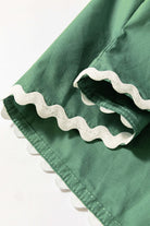 Close-up of Garden Gala Top showcasing misty green fabric with playful ivory ric rac trim detail.