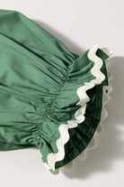 Close-up of Garden Gala Top's misty green fabric with ivory ric rac trim on the hem, showcasing its vintage charm.