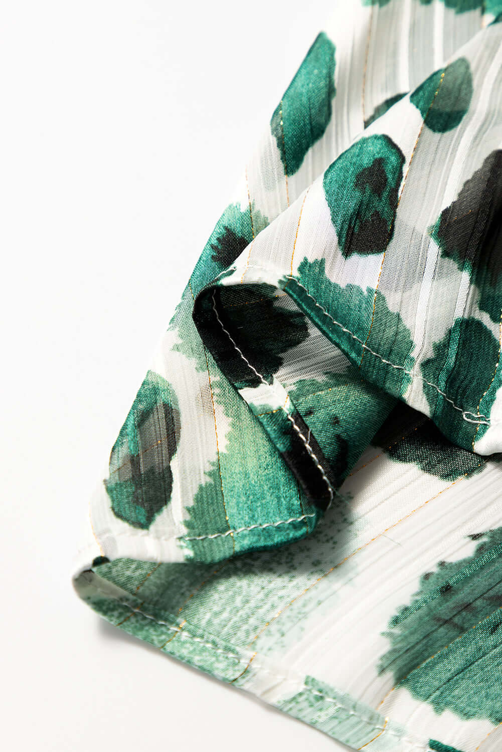 Close-up of the Enchanted Valley blouse showcasing playful green spotted fabric and 3/4 ruffled sleeves.