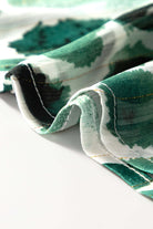 Close-up of the Enchanted Valley blouse fabric featuring green watercolored spots and delicate ruffled edges.