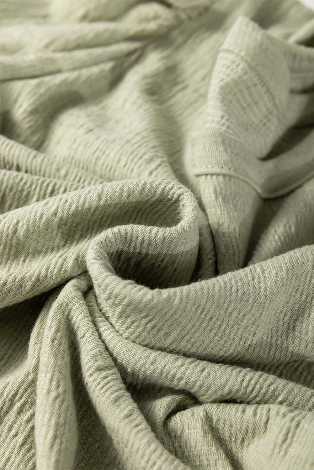 Textured minty sage fabric showcasing soft, luxurious feel for the Alpine Mist Top, perfect for stylish outfits.