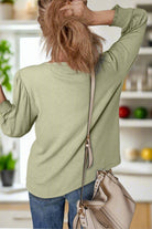 Elegant minty sage blouse with half sleeves, styled for comfort and chic appeal, paired with a fashionable bag.