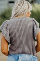 Back view of the Sound Wave top, showcasing textured ruffle sleeves in a taupe-gray hue.