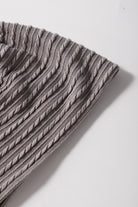 Textured taupe-gray fabric of the Sound Wave top featuring cable-knit design and ruffle sleeves.