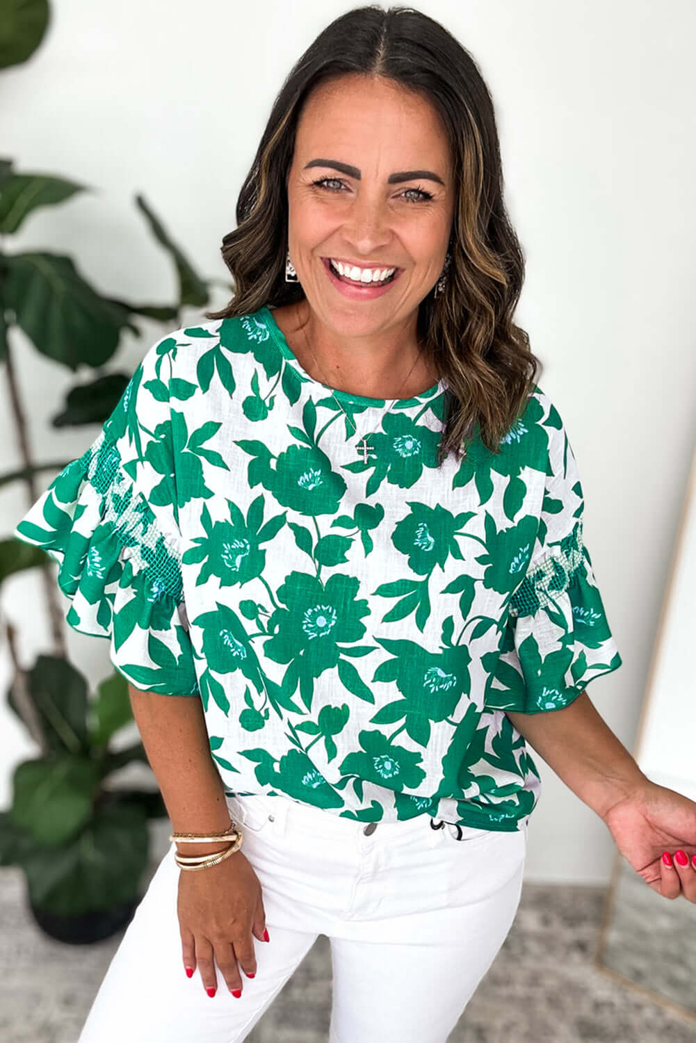 Woman wearing the Jade Blooms Top, featuring green floral print and ruffled sleeves for a feminine look.