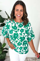 Women wearing the Jade Blooms Top with a floral print and ruffled sleeves, styled for a chic and feminine look.