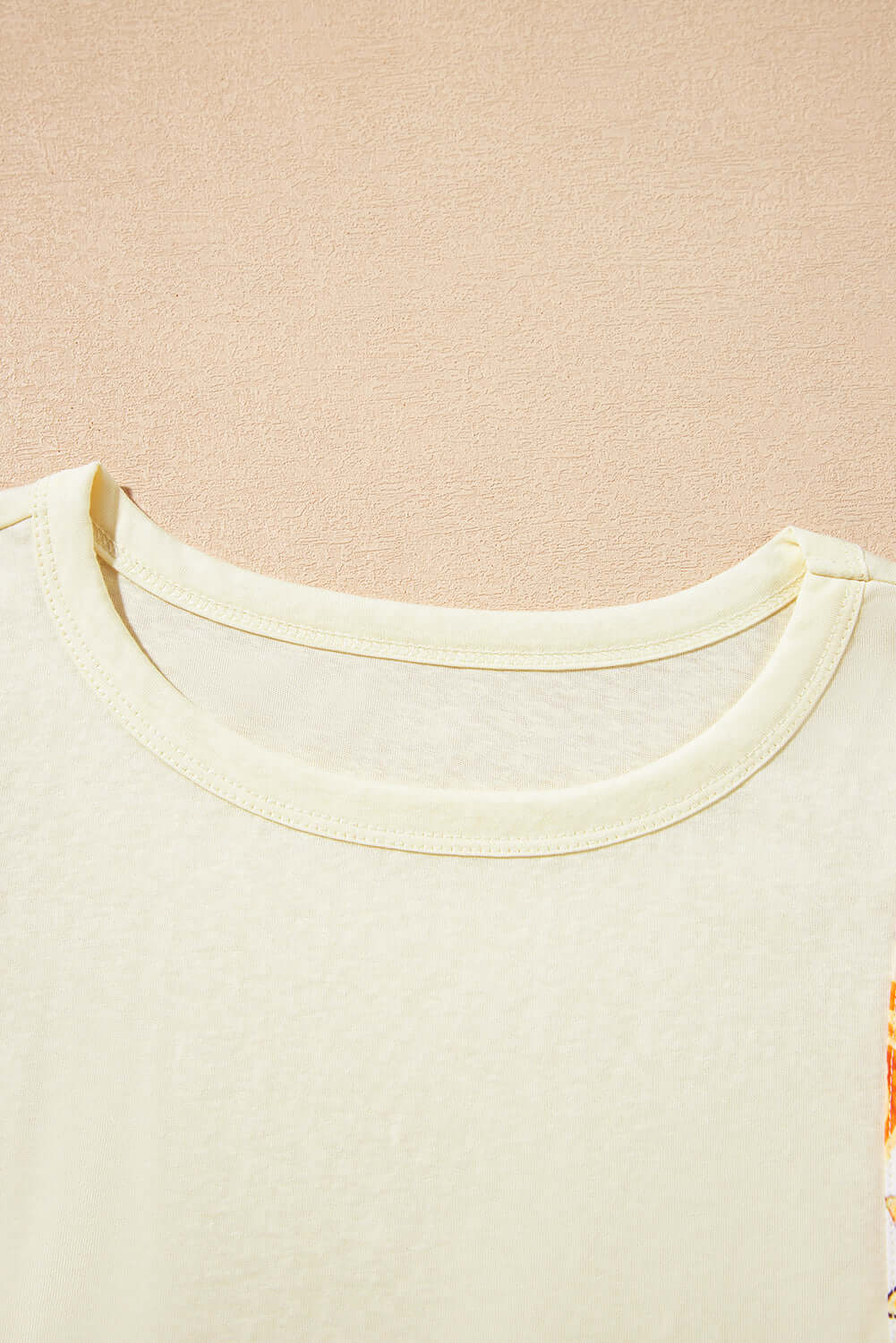 Close-up of the round neck and fabric texture of the Sun Dance top with floral prints.