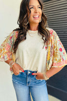 Woman in bohemian Sun Dance top with floral patchwork, styled with jeans and accessories.