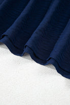 Close-up of Tide and Treasure blouse fabric showcasing navy texture on a light background.