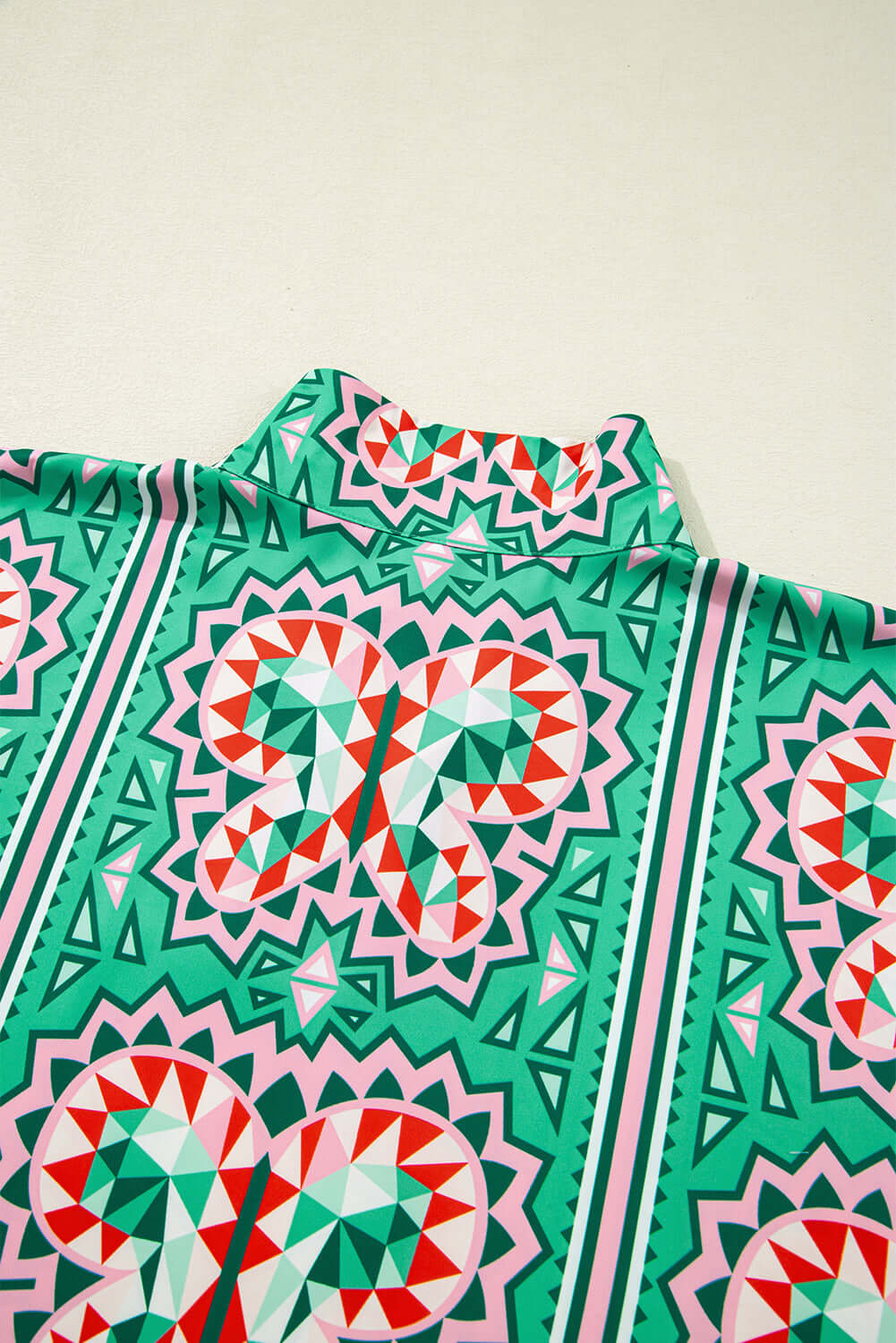 Abstract Energy Top featuring vibrant sea green, coral, and blush geometric print and striped collar.
