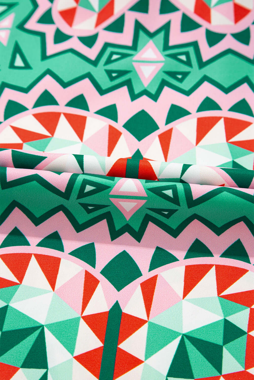 Colorful abstract geometric pattern in sea green, coral, and blush on lightweight fabric.