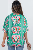 Back view of a sea green abstract print blouse with geometric patterns and short sleeves.