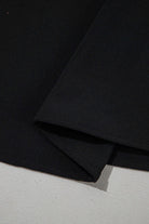 Close-up of black fabric detailing on Fringe Benefits Ruffle Sleeve Blouse, showcasing its soft texture and hem design.
