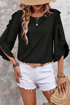 Fringe Benefits top in black with ruffled sleeves, styled with white shorts and a trendy hat for chic summer look.