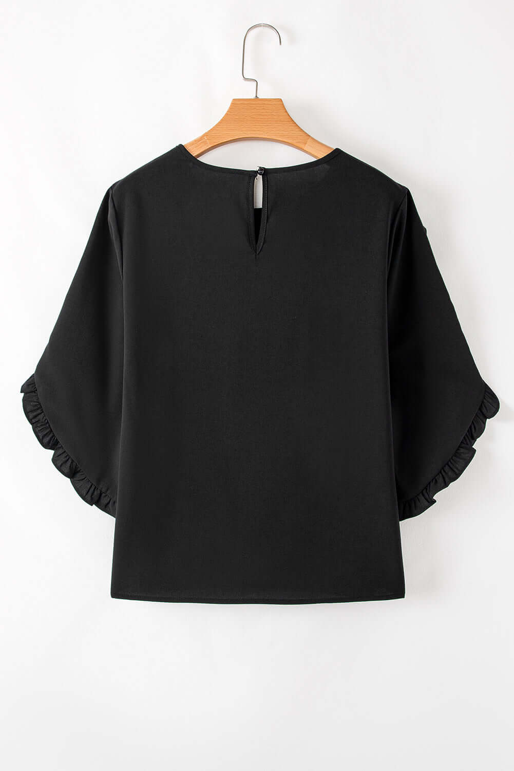 Back view of Fringe Benefits black blouse featuring ruffle sleeves and a stylish keyhole closure.