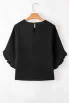 Back view of Fringe Benefits black blouse featuring ruffle sleeves and a stylish keyhole closure.