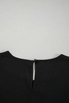 Back view of the black Fringe Benefits top featuring a keyhole opening and zipper detail.
