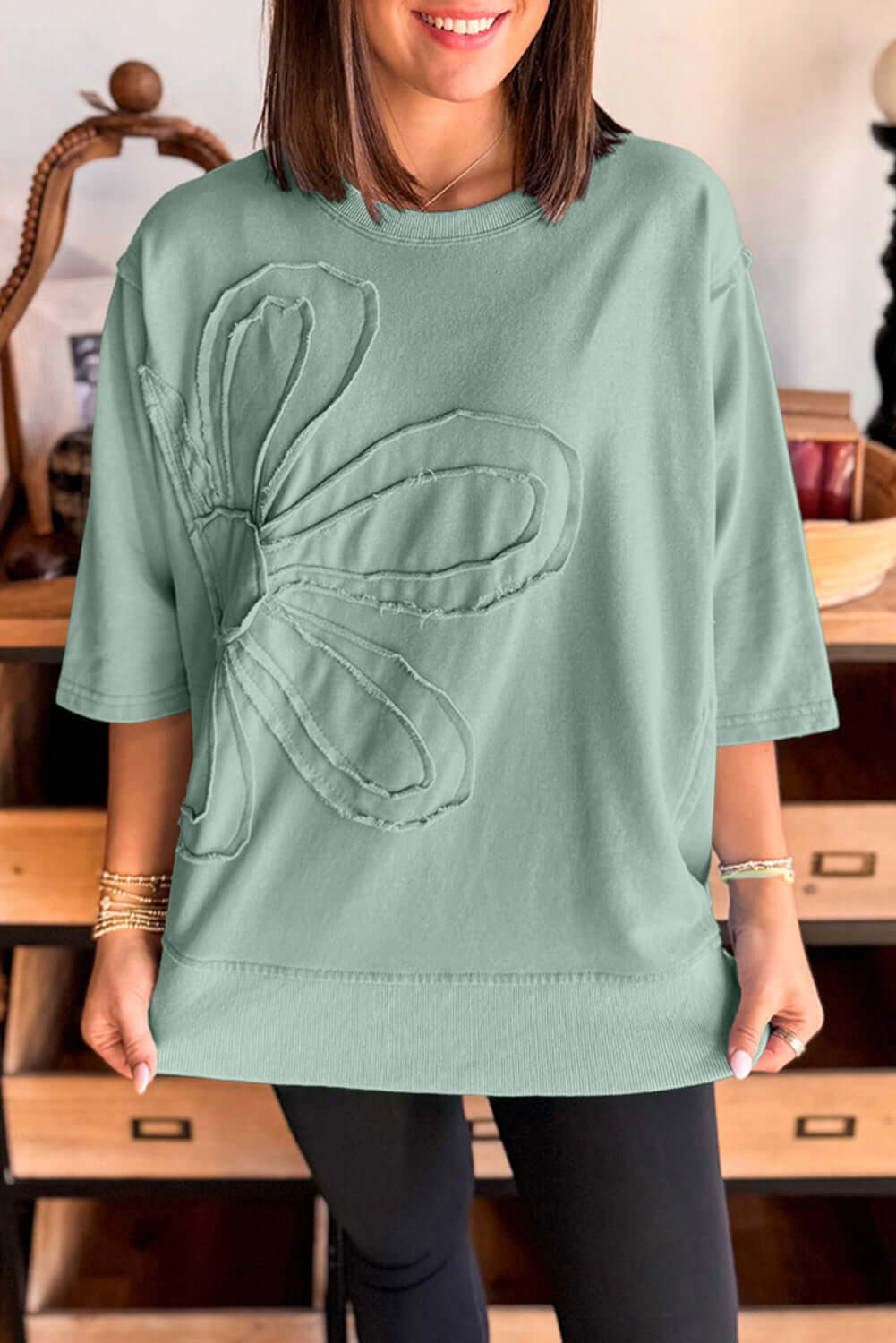 Casual sea green Flower Theory Top with oversized floral design and relaxed fit.