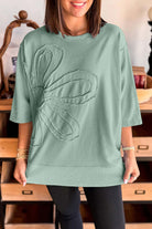 Casual sea green Flower Theory Top with oversized floral design and relaxed fit.