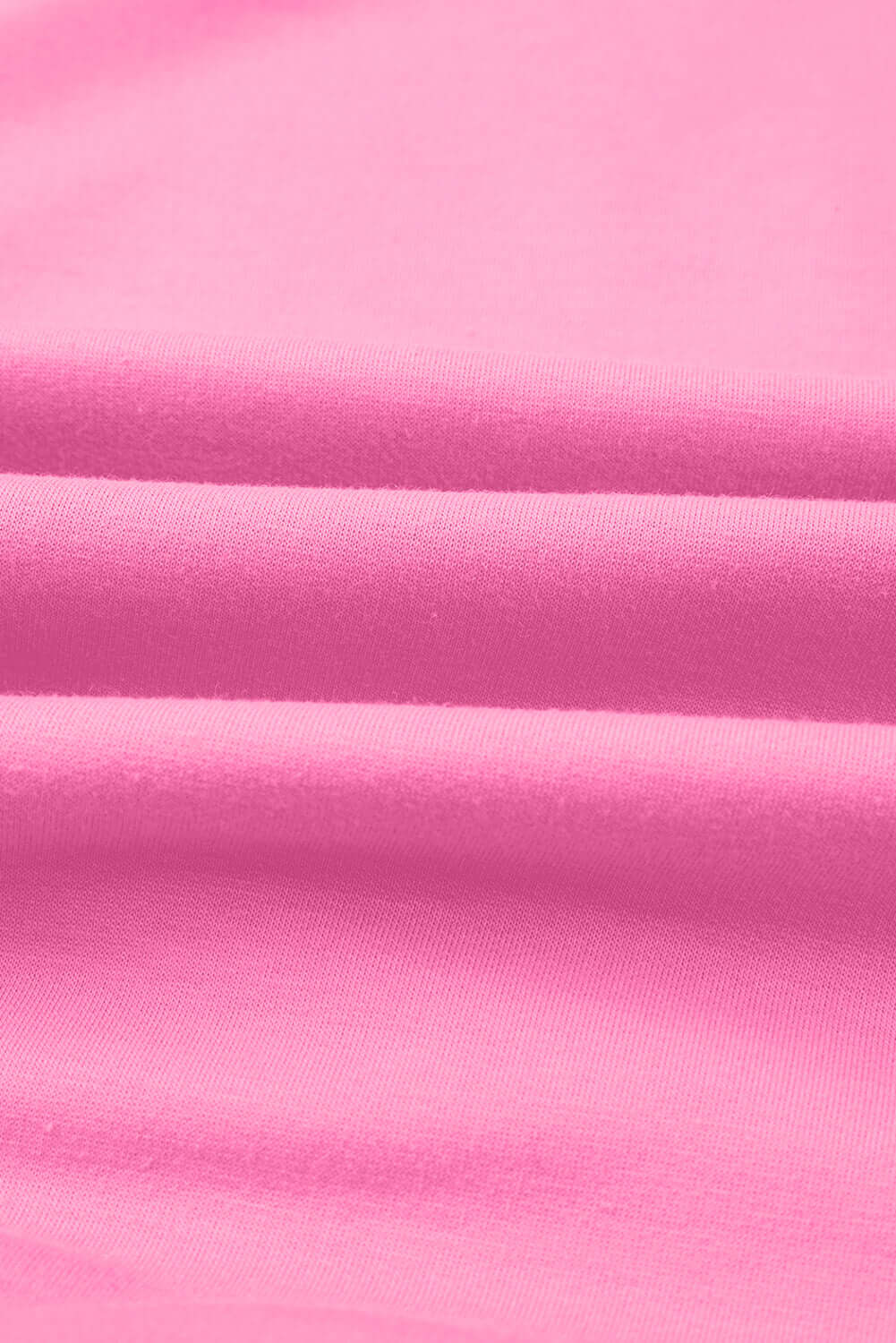 Close-up of soft, taffy pink fabric showcasing smooth texture, perfect for casual wear like the Flower Theory Top.
