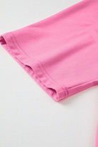 Close-up of the sleeve hem of a pink taffy Flower Theory Top, showcasing soft knit fabric and relaxed fit.