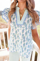 Flora Belle Top featuring blue and green floral print, V-neck, and stripe trim for a chic garden-inspired look.