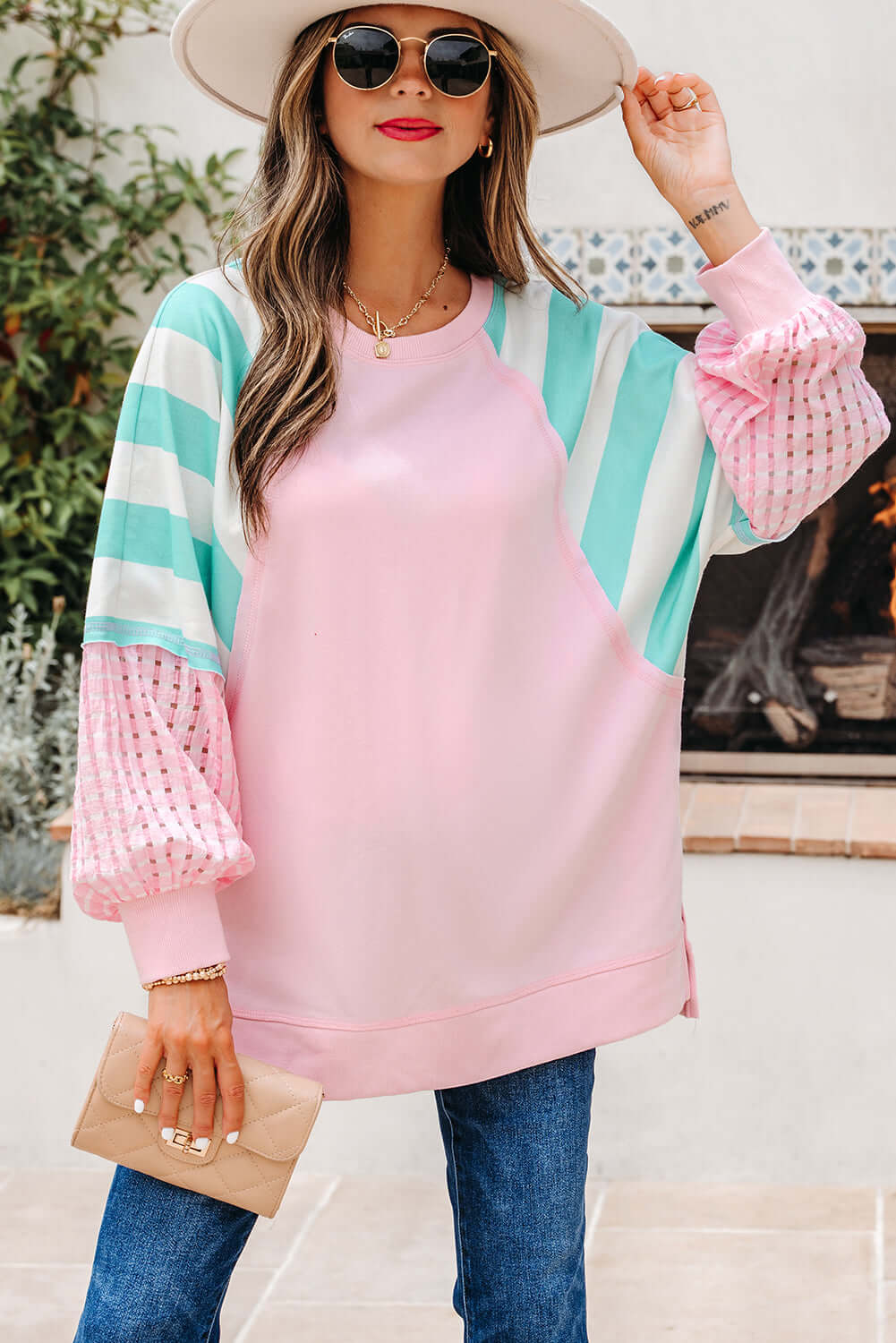 Woman wearing a SWEET ESCAPE TOP featuring pastel striped colorblock design, styled with a wide-brim hat and sunglasses.