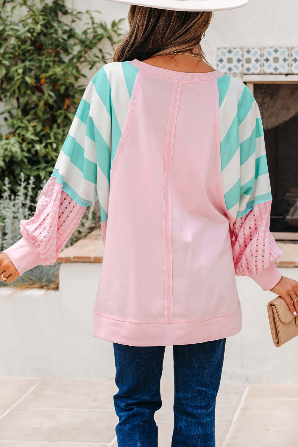 Back view of the SWEET ESCAPE TOP, showcasing its colorful striped design and loose pullover style.