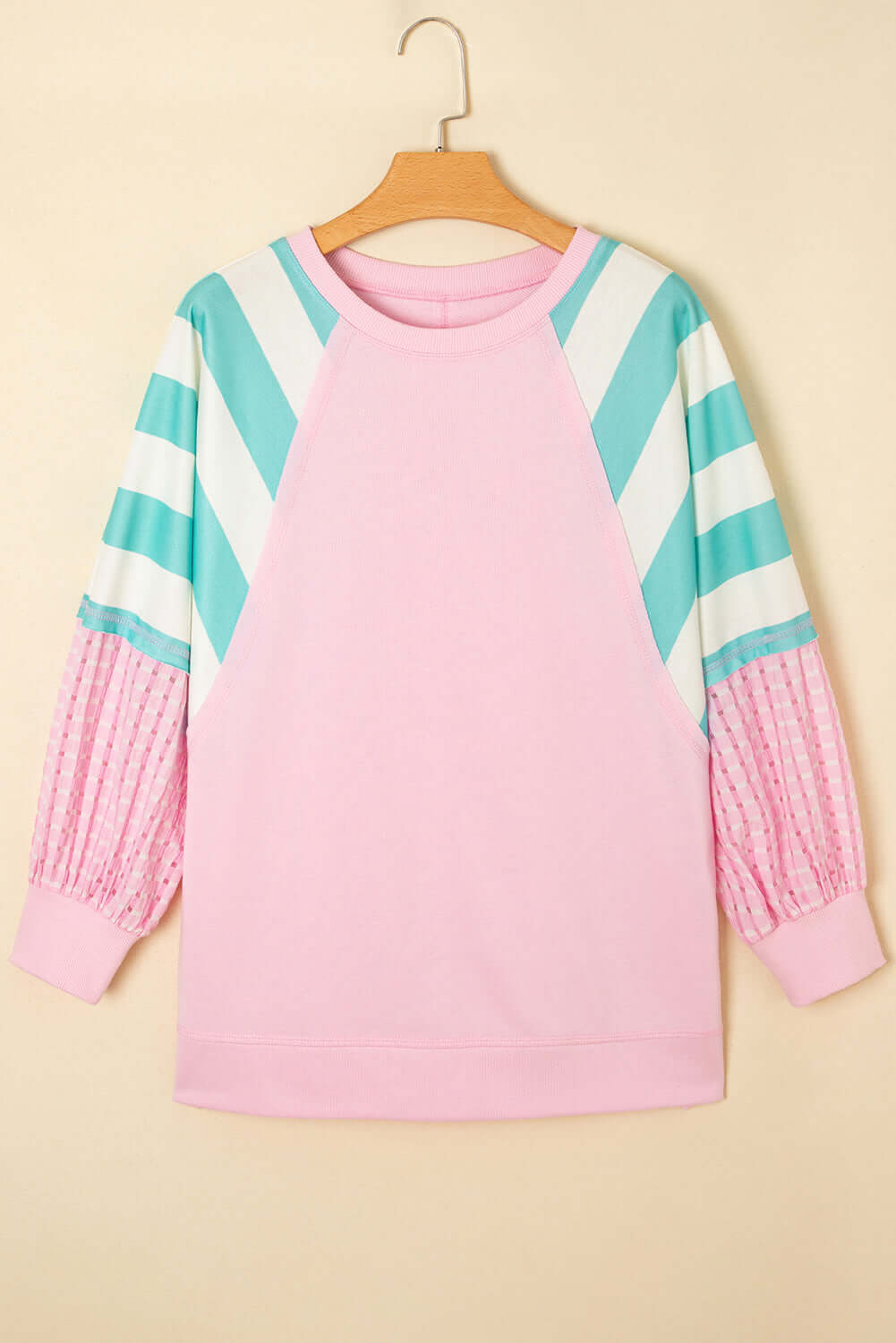 SWEET ESCAPE TOP featuring a pink pullover with striped colorblock sleeves in playful pastel tones.