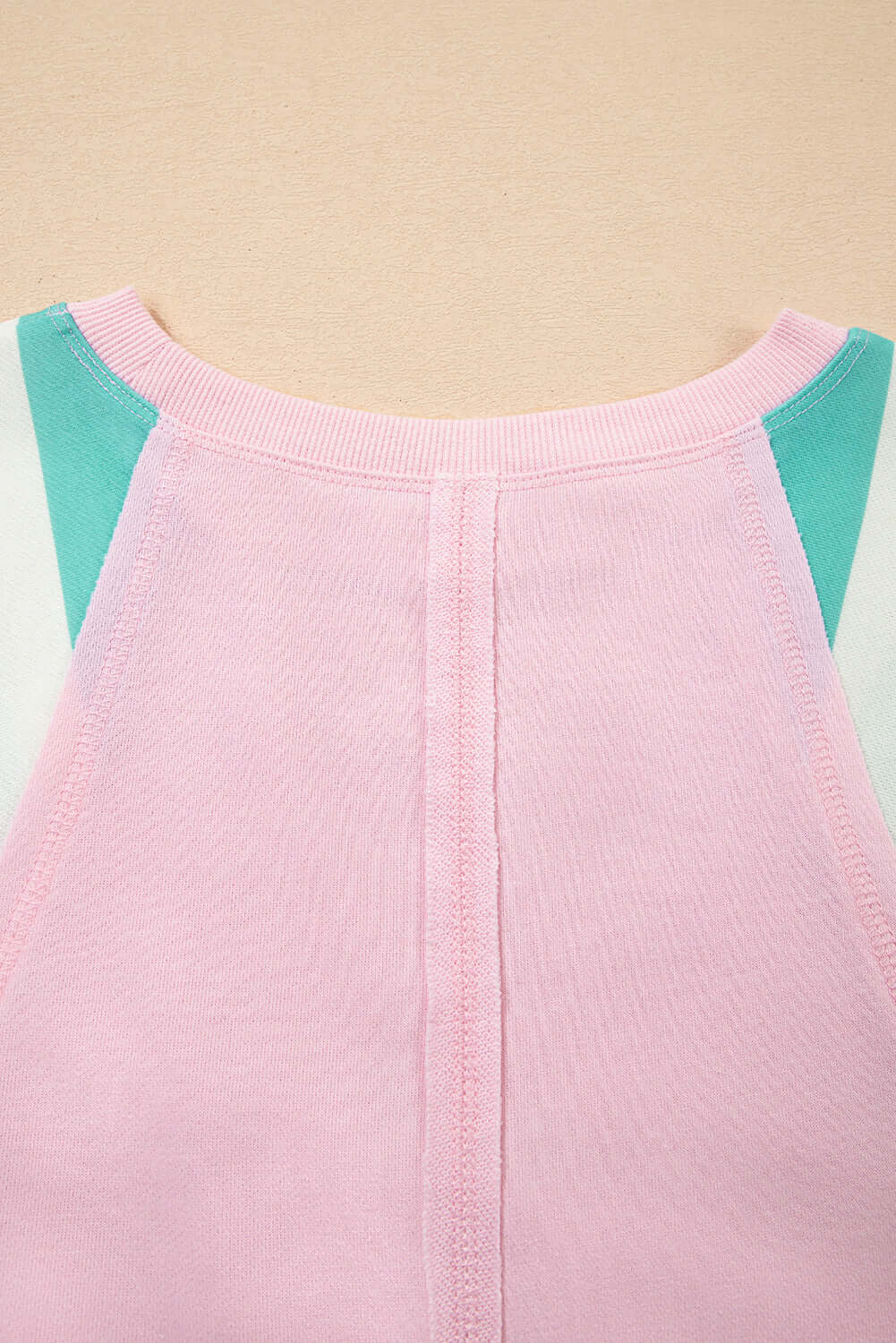 Back view of the SWEET ESCAPE TOP featuring a pastel colorblock design with pink and teal accents.