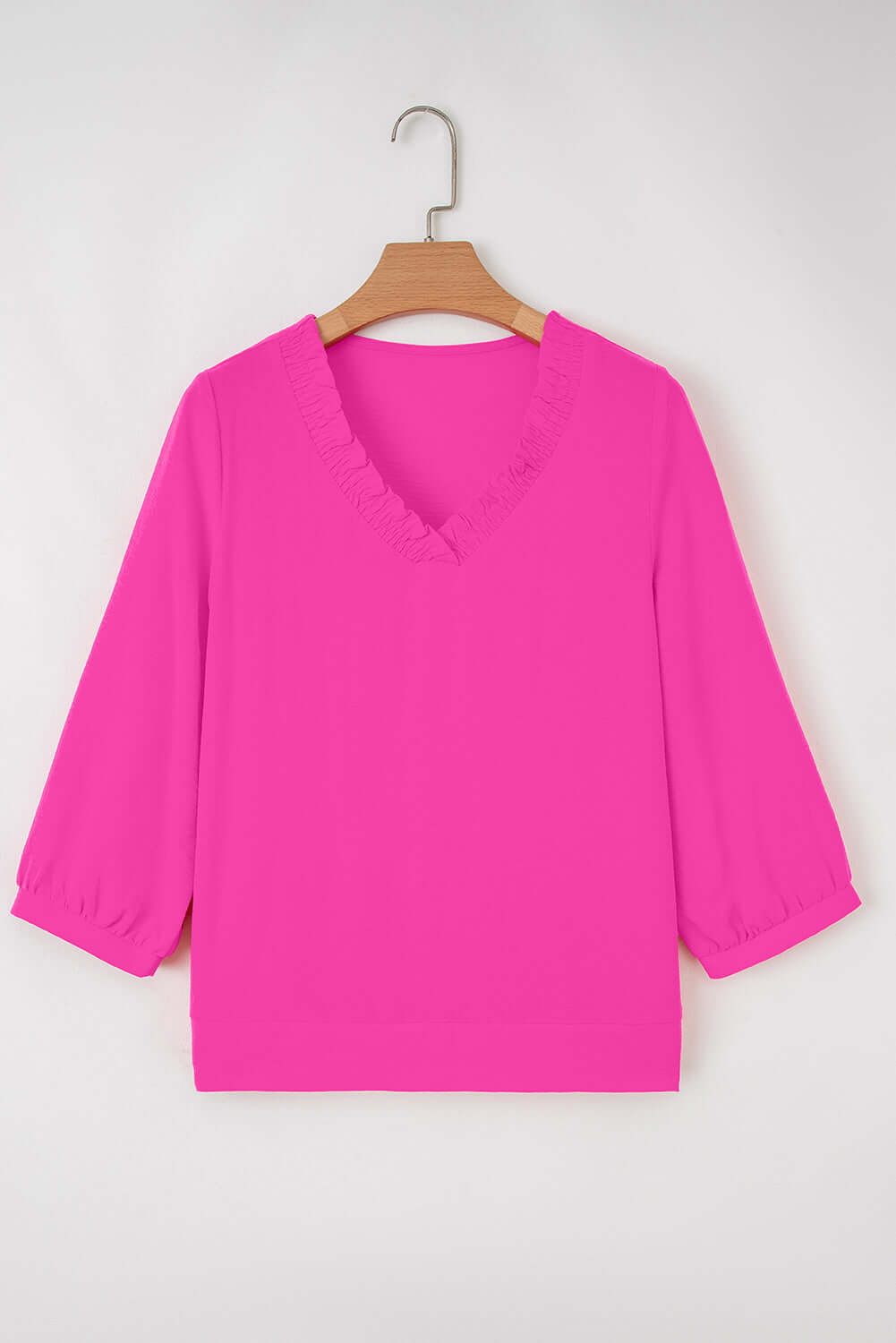 GRACEFUL GLOW TOP (bright pink) featuring a frilled V-neckline and bracelet sleeves hanging on a hanger.