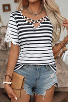 Crisscross Charisma Top with black and white stripes and lace sleeves, styled with denim shorts.
