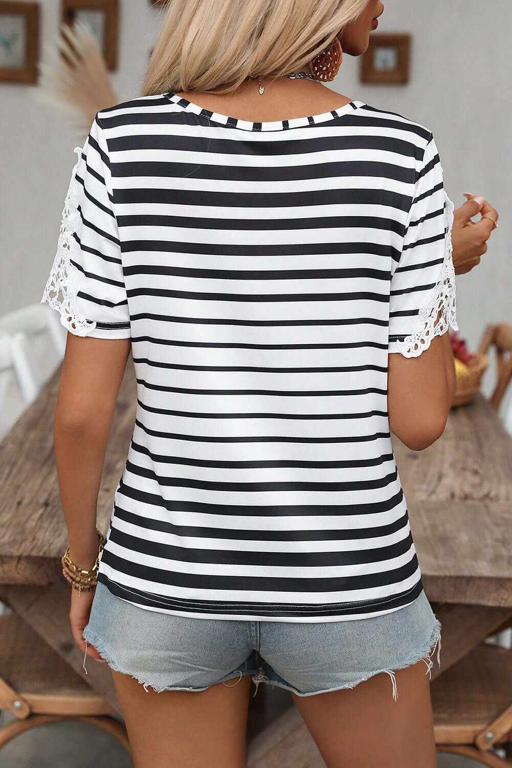 Back view of Crisscross Charisma Top featuring black stripes and lace-accent short sleeves.