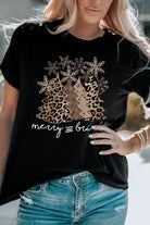 Woman wearing Merry & Bright Leopard Tee with Christmas tree graphic in leopard print, festive holiday fashion attire.