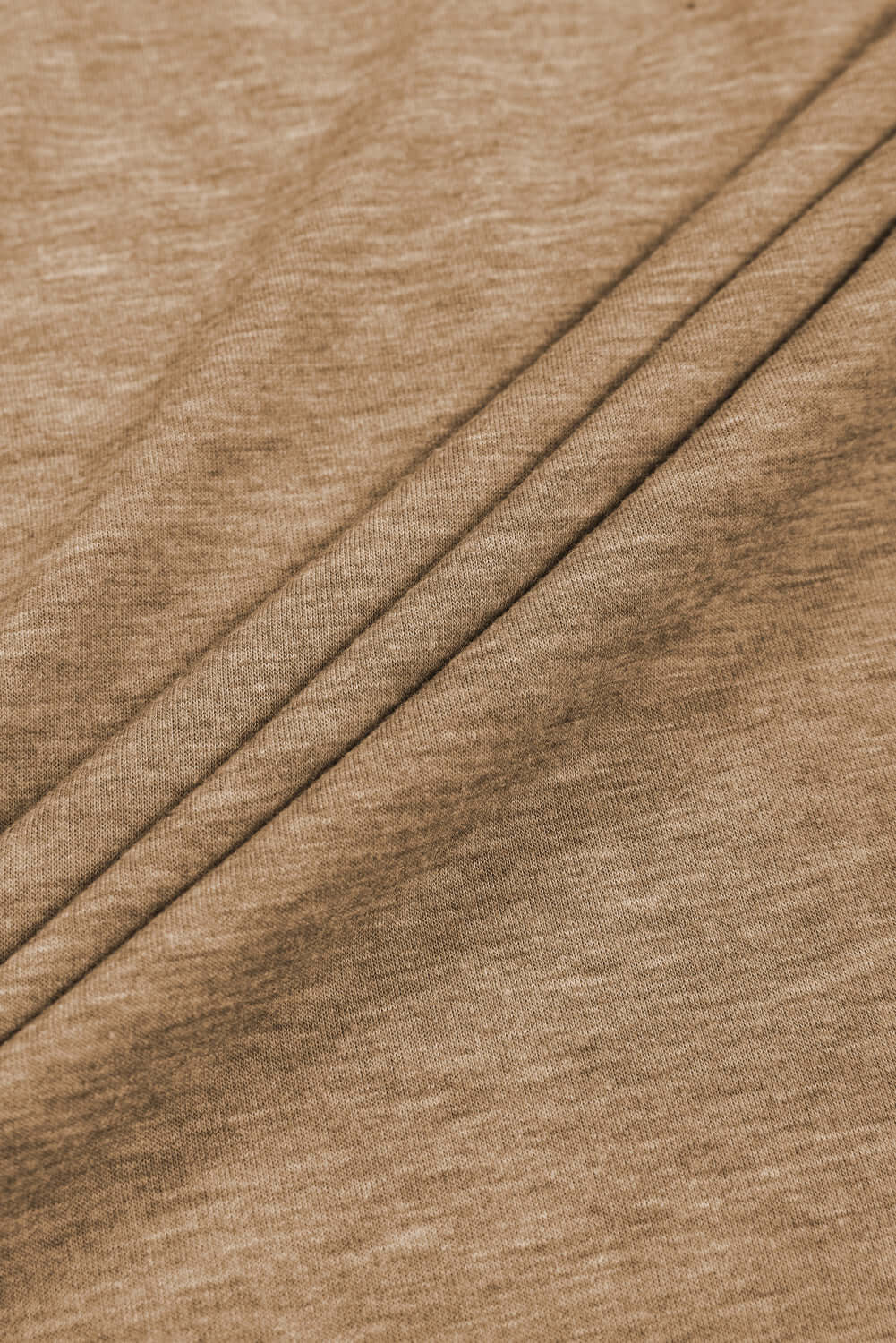 Close-up of soft, textured beige fabric with pleats, perfect for elegant fashion designs.