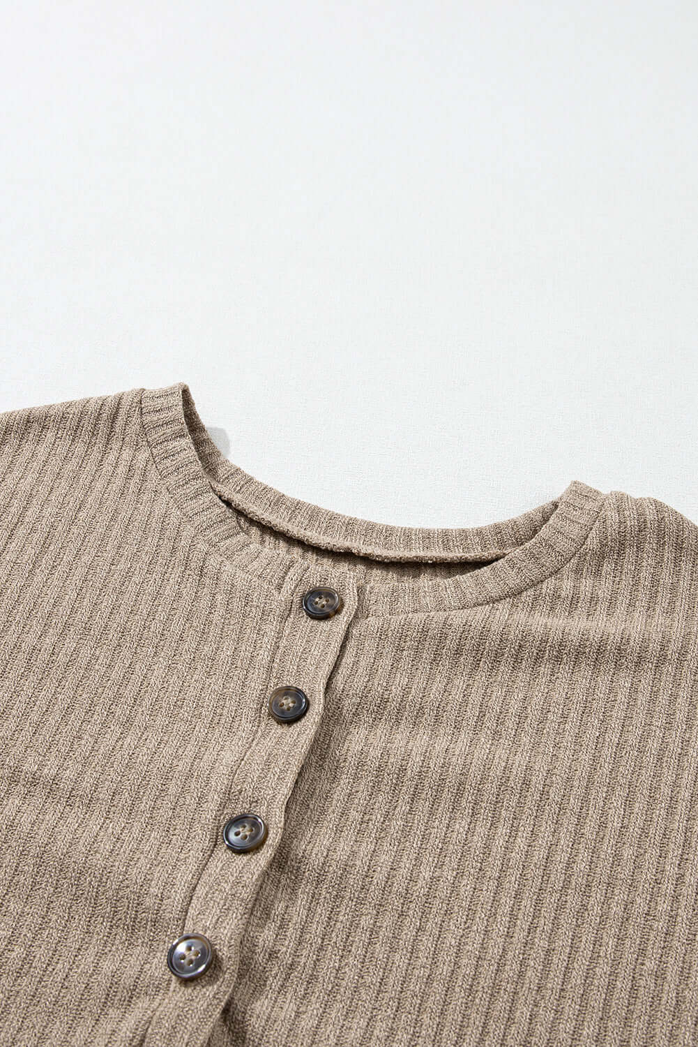 Close-up of UNLIMITED POTENTIAL knit top by Vivian-Lu featuring Henley design and ribbed texture in beige color.