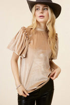 Woman wearing champagne velvet Date Night Top by Vivian-Lu with ruffled puff sleeves and a mock neck.