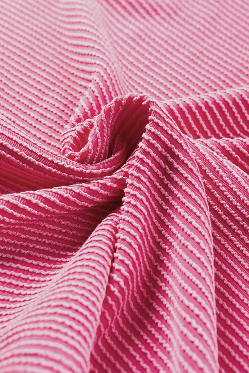 Close-up of soft pink striped fabric, showcasing the ribbed texture perfect for stylish apparel like the HAPPY THOUGHTS Top.