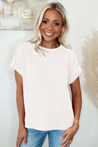 Woman smiling in a light ivory VANILLA VIBE ribbed top, showcasing relaxed fit and soft texture.