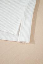 Close-up of the ribbed hem of a soft ivory top, showcasing lightweight texture and elegant design.