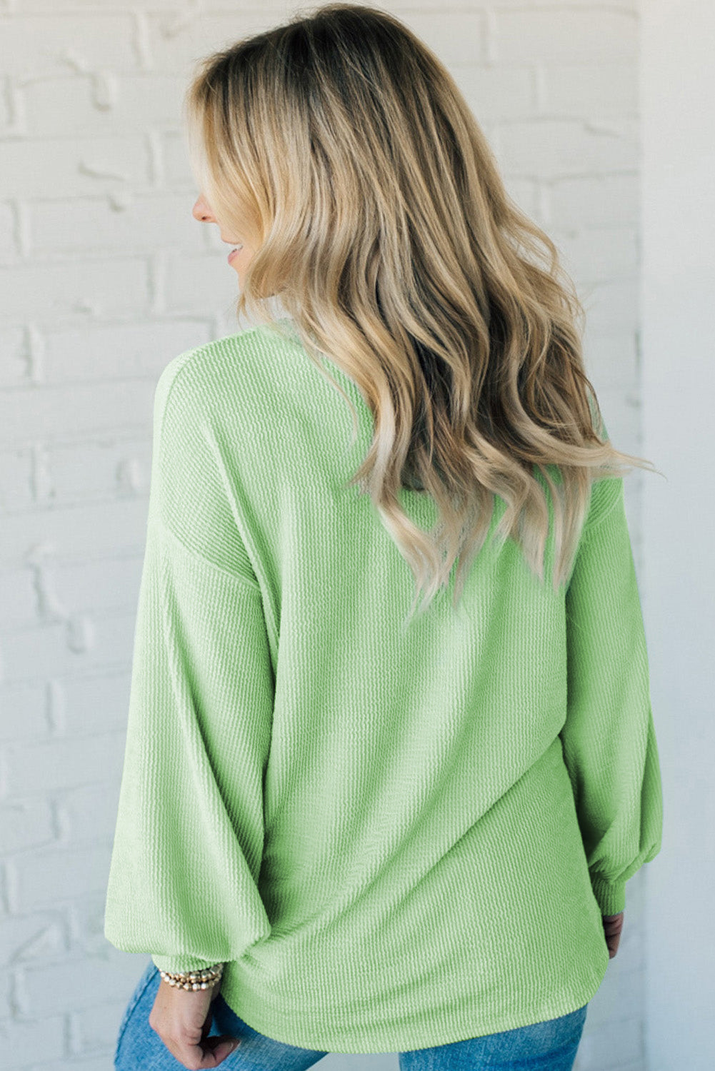 Woman wearing Minty Fresh top with ribbed texture and drop shoulder design, showcasing casual style in a solid light green color.