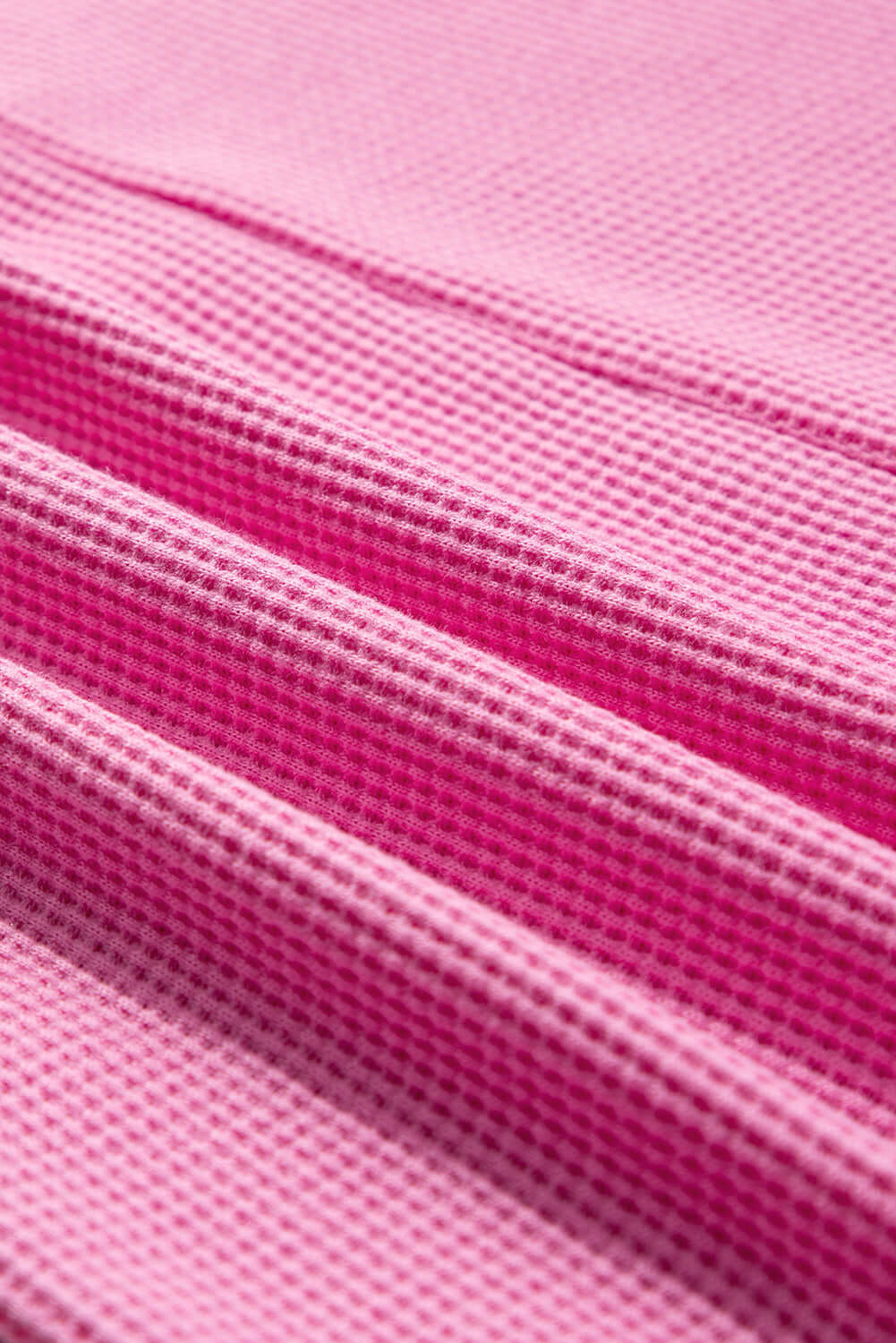 Close-up of textured pink ribbed fabric showcasing intricate stitching details.