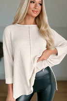 Cozy waffle knit top with batwing sleeves and splits, perfect for casual wear, paired with black leggings for a stylish look.