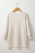 Cozy Vivian-Lu waffle knit top with batwing sleeves in off-white, hanging on hanger against plain background.