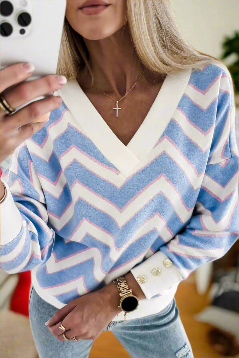 Woman wearing a Chevron Chic top with blue and white zigzag stripes, featuring a relaxed fit and buttoned cuffs.