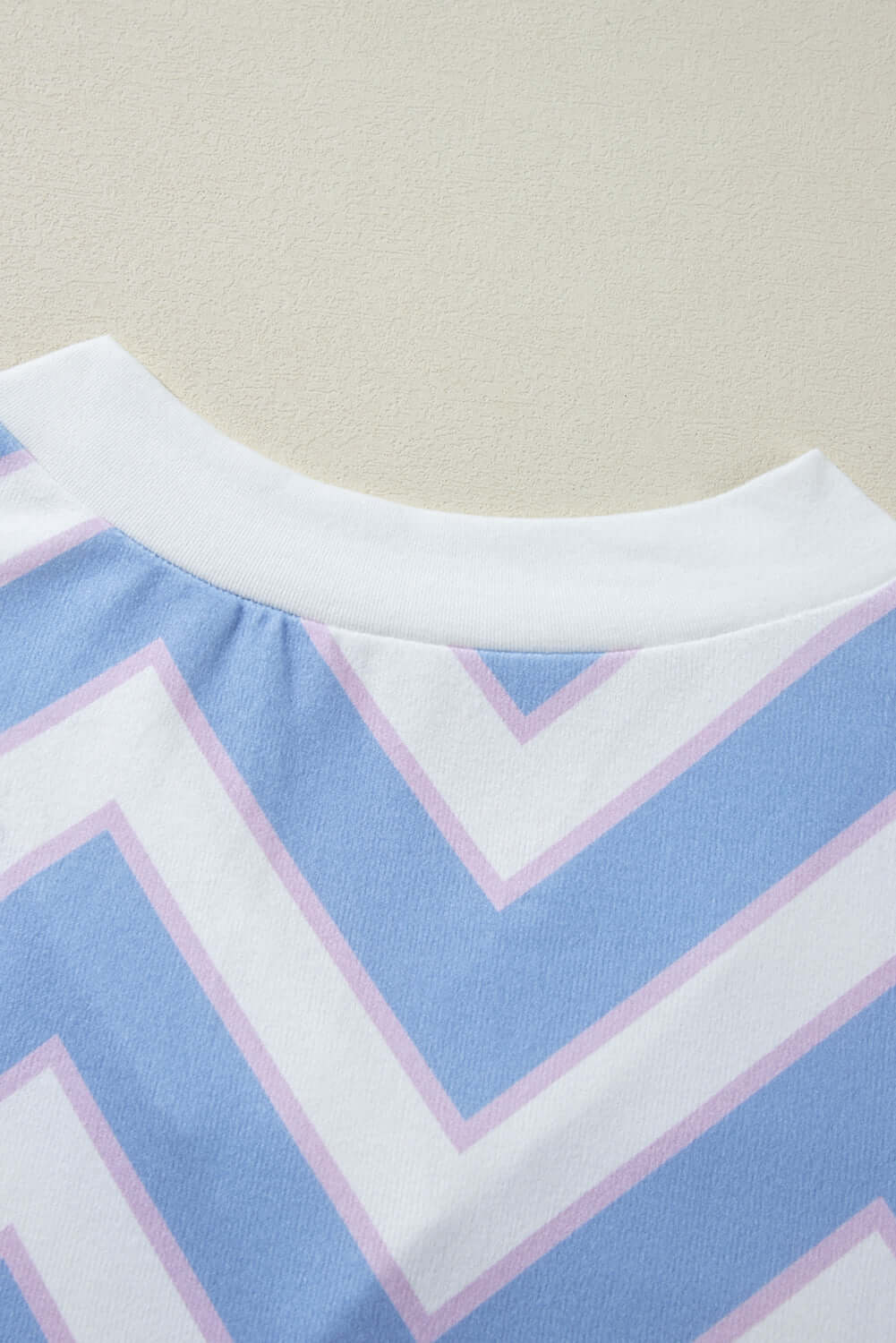 Close-up of the Chevron Chic top's zigzag stripe pattern in blue and pink, showcasing the relaxed neckline and stylish detail.