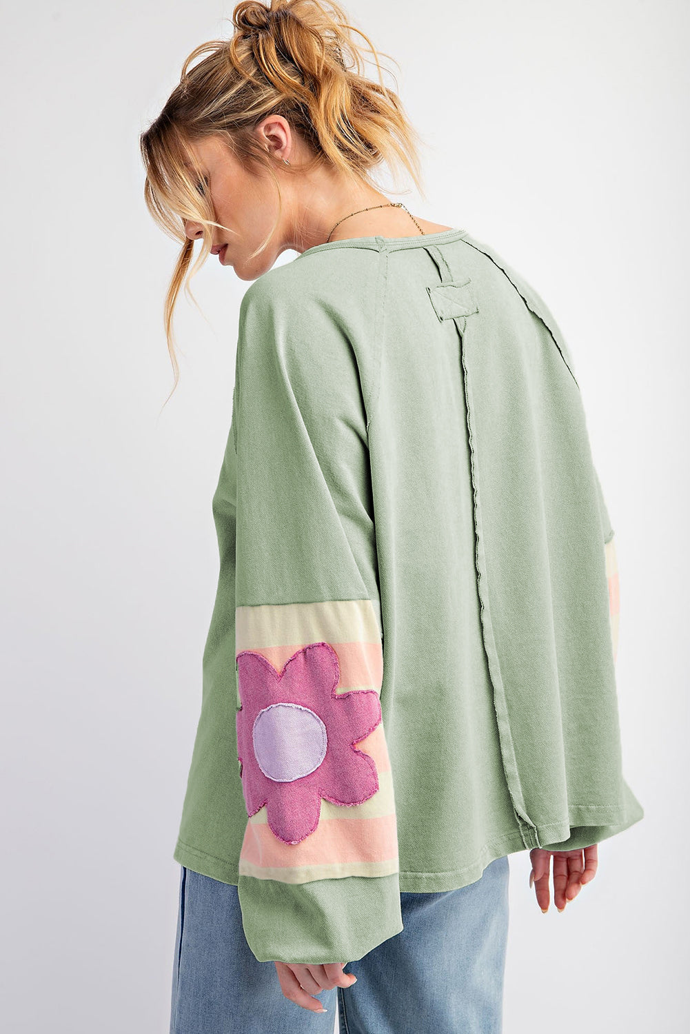 Oversized sage pullover with vintage flair, featuring bubble sleeves with flower pattern, exposed seams, and raw cut details.